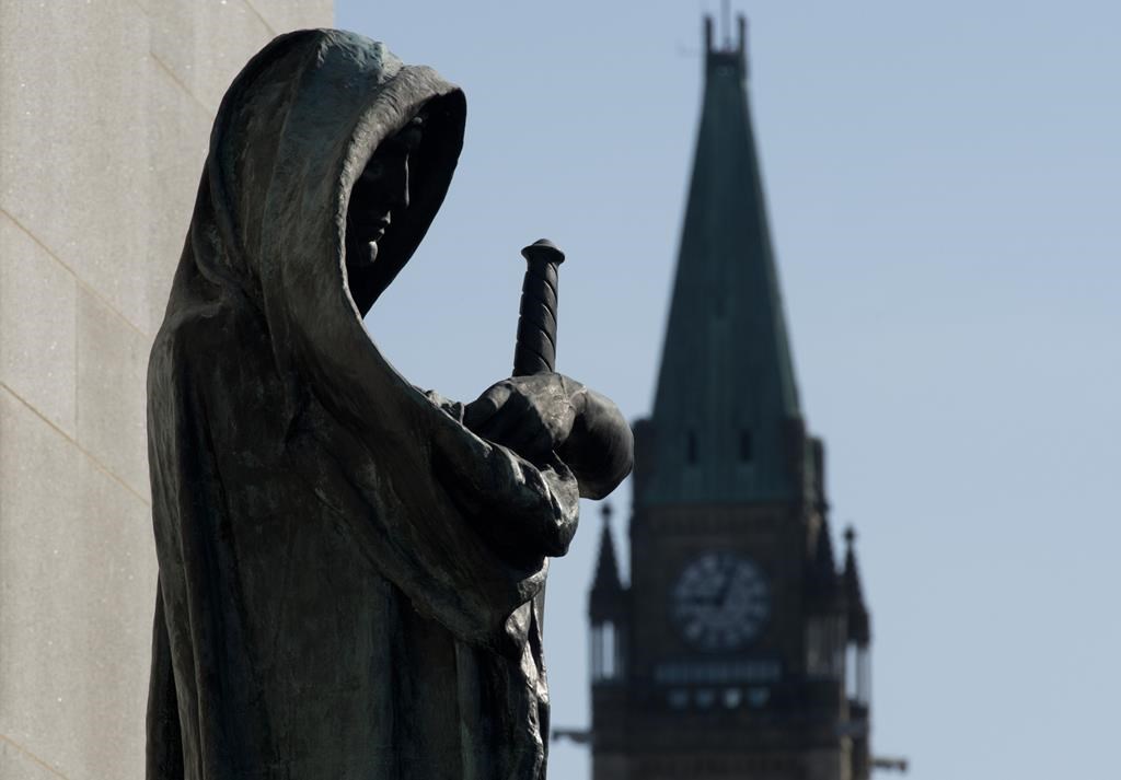 Veritas (Truth) guards the entrance of the Supreme Court of Canada as the Peace tower is seen in the background in an April 25, 2014 photo in Ottawa. The Supreme Court of Canada says an Ontario high-school teacher who used a pen camera to surreptitiously take videos of female students is guilty of voyeurism. Teacher Ryan Jarvis was charged with voyeurism after discovery of more than two dozen videos on his pen, many of which focused on the chests and cleavage area of students at the London, Ont., school.