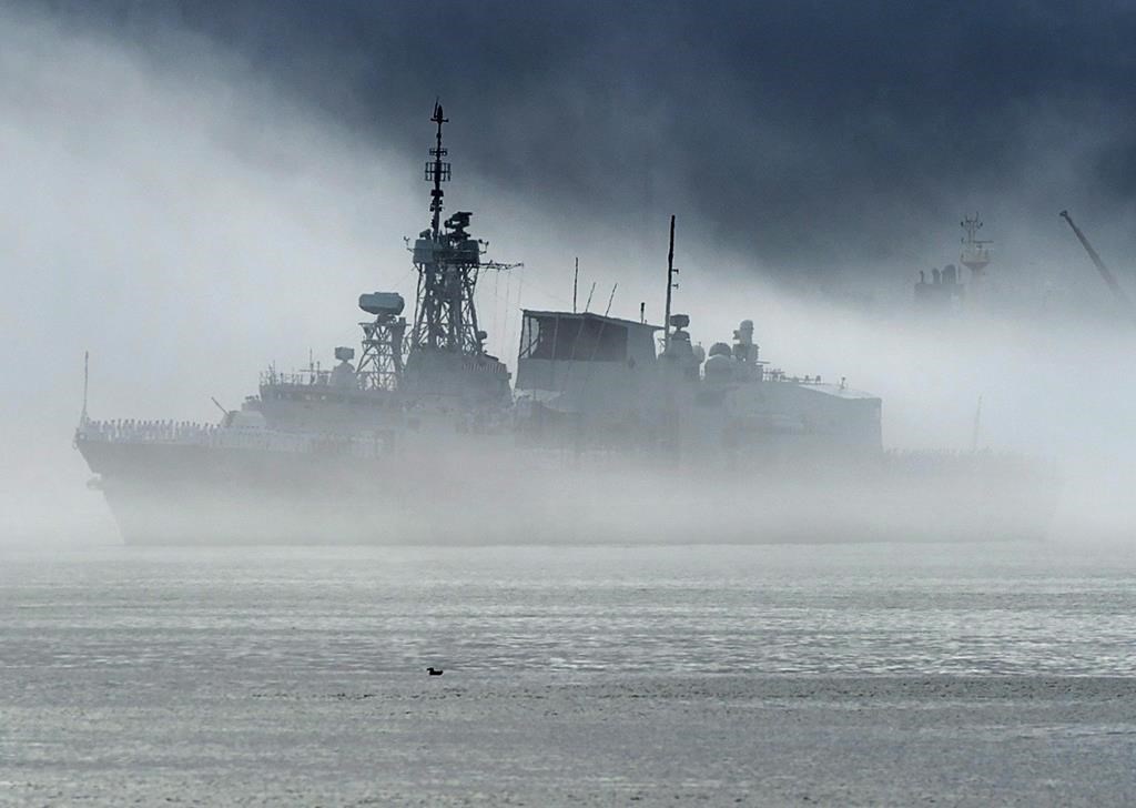 HMCS St. John's, one of Canada's Halifax-class frigates, heads through the fog as it returns to port in Halifax on Monday, July 23, 2018.
