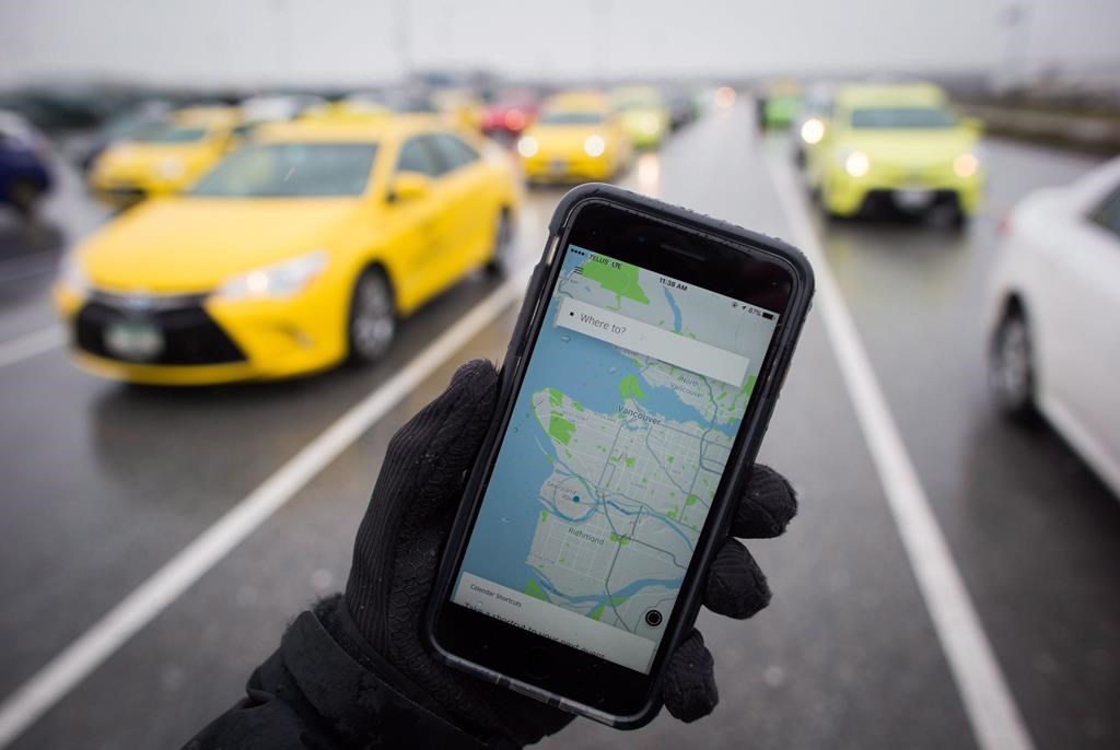 The Uber app is displayed on an iPhone as taxi drivers wait for passengers at Vancouver International Airport, in Richmond, B.C., on Tuesday March 7, 2017.