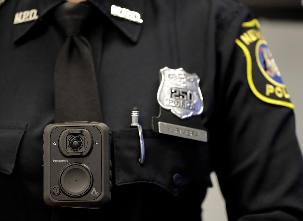Newark police officer Veronica Rivera displays how a body cam is worn during a news conference unveiling the department's new cameras at the Panasonic headquarters in Newark, N.J., Wednesday, April 26, 2017.