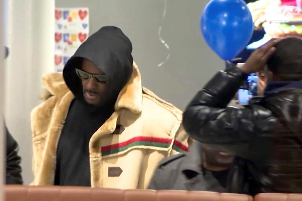 In this image made from a video, R. Kelly stops at a McDonald’s restaurant in Chicago Monday, Feb. 25, 2019, after a suburban Chicago woman posted the $100,000 bail for R. Kelly to be freed from jail while he awaits trial on sexual abuse charges. R. Kelly signed autographs and waved at a fan who yelled “I love you!” when he stopped at McDonald’s in downtown Chicago. (WFLD via AP)