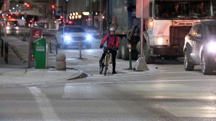 A cyclist waits at a red light in one of Calgary's downtown cycle tracks. Cycling advocates in Calgary are calling for safer bike infrastructure across the city after numerous reports of icy and snowy bike lanes from cyclists. .