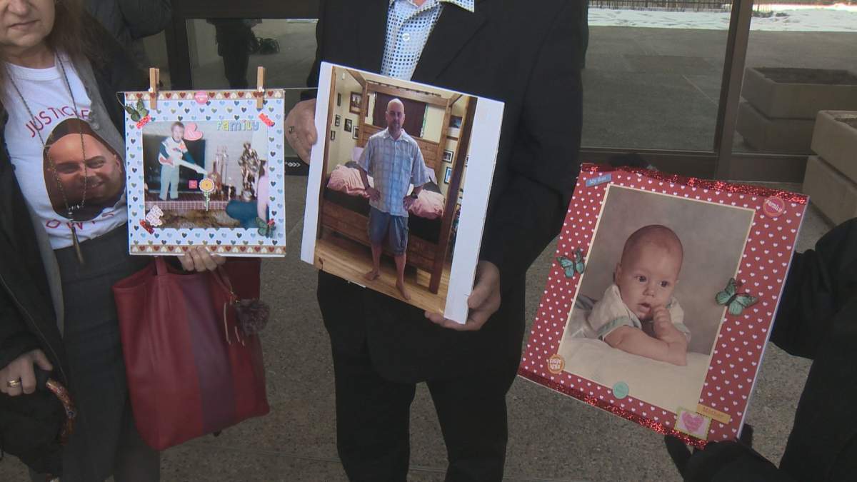 Dwayne Demkiw’s family hold up pictures of him outside court Friday, Feb. 22, 2019.
