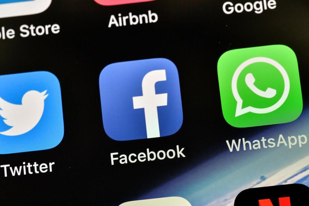 In this Thursday, Nov. 15, 2018 file photo the icons of Facebook and WhatsApp are pictured on an iPhone in Gelsenkirchen, Germany.