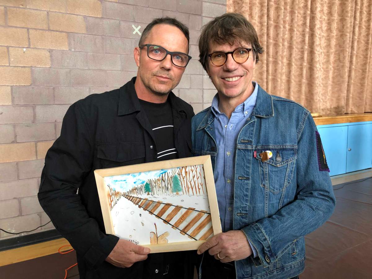 Patrick (left) and Mike Downie pose with a drawing that was gifted to them at Antler River Elementary School in Chippewas of the Thames First Nation.