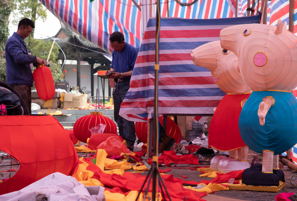 Artisans make colored lanterns featuring animated series Peppa Pig characters at a square to welcome the New Year.