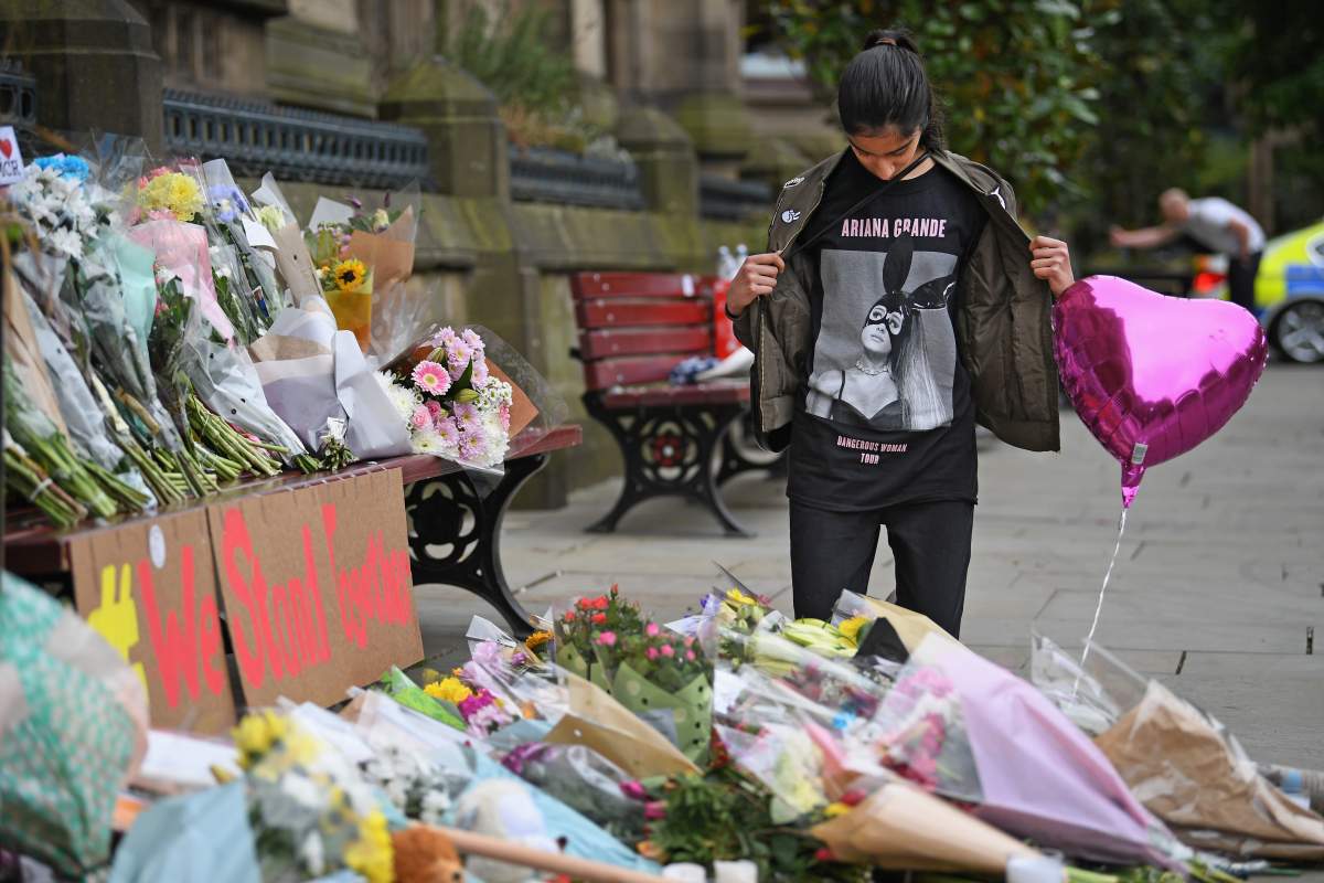 Iqra Saied, 13, who attended the Ariana Grande concert victim of the tragic bombing attack looks at floral tributes and messages as the working day begins on May 24, 2017, in Manchester, England.