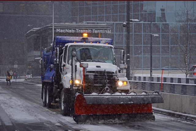 A plow clears snow in downtown Hamilton.