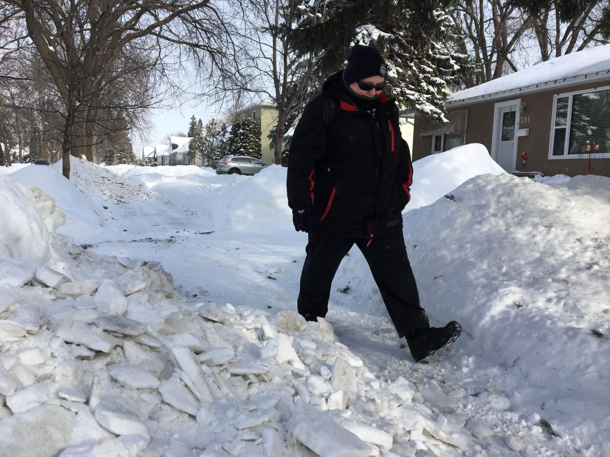 Brittnay Maydaniuk making her way around a pile of snow on Lyle Street.