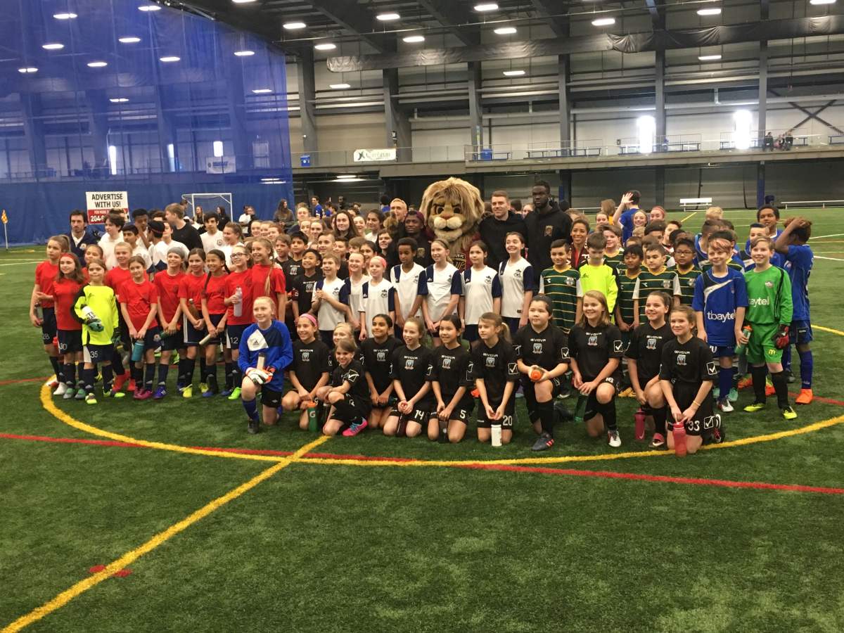 Vic poses with children at the Winnipeg Soccer Federation North complex on Leila Avenue Saturday.