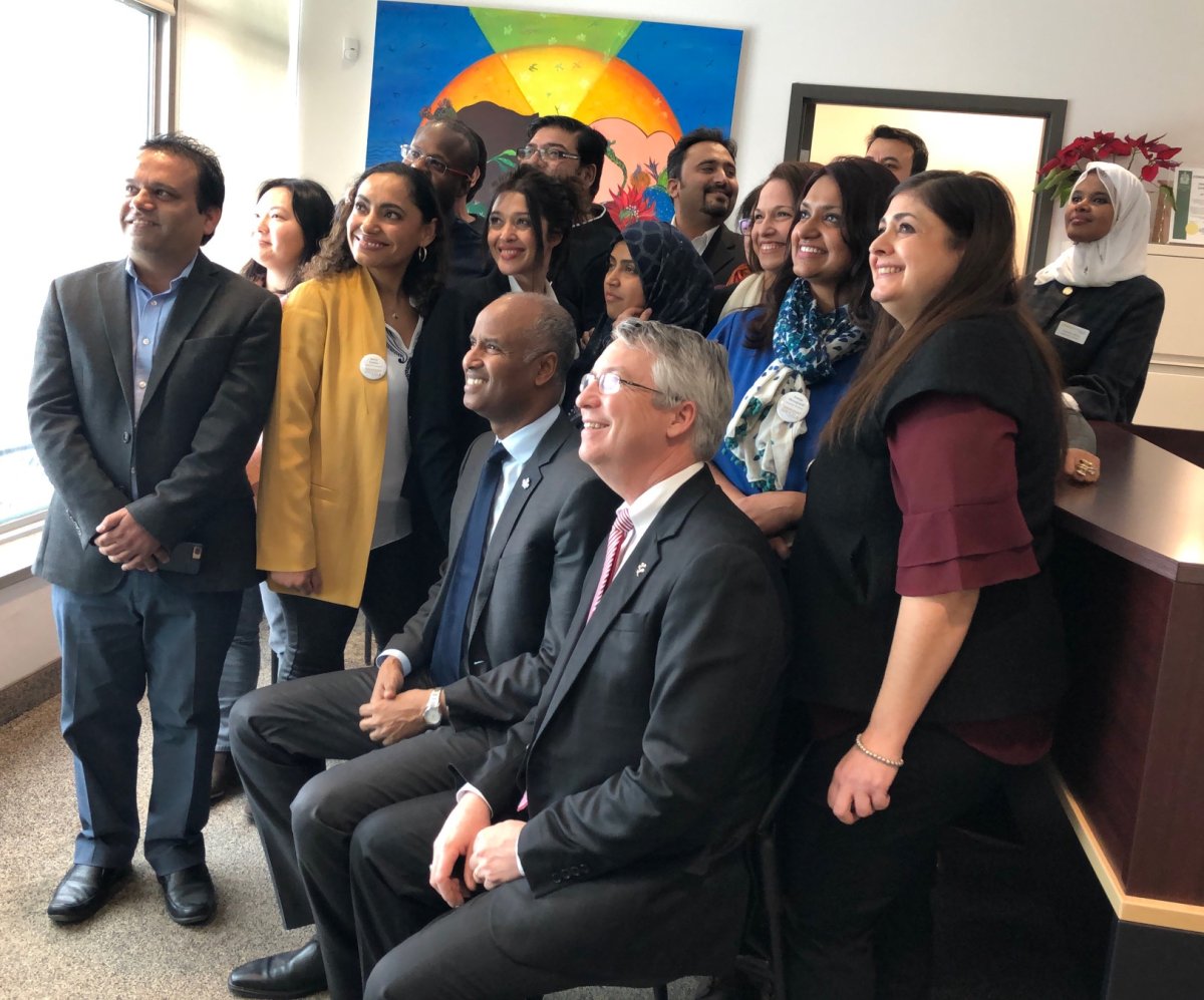 Immigration Minister Ahmed Hussen and Guelph MP Lloyd Longfield (both seated) take a photo with community members and stakeholders at Immigrant Services Guelph-Wellington.