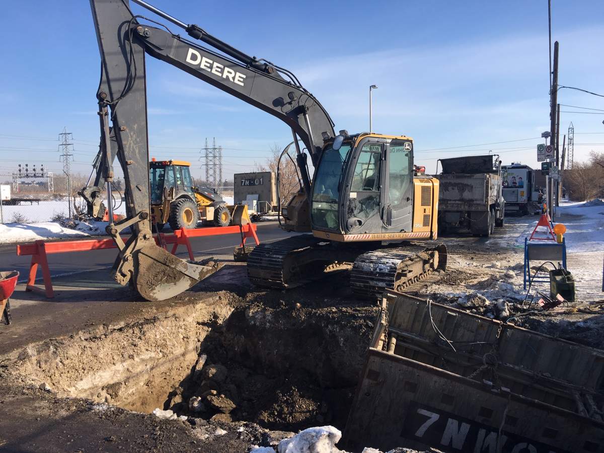 Crews work to clean up a water main break in Calgary on Wednesday, Feb. 6.