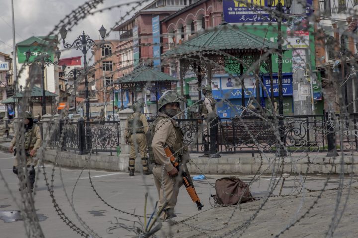 In this Saturday, May 19, 2018, file photo, Indian Paramilitary soldiers are seen through barbed wire in Srinagar, Indian controlled Kashmir.