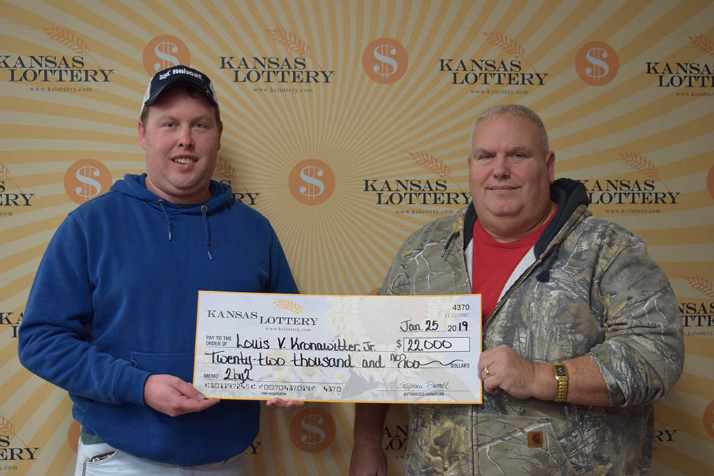 Austin Kronawitter, left, and his father and Kansas Lottery winner Louis V. Kronawitter Jr., right, post with a $22,000 cheque.