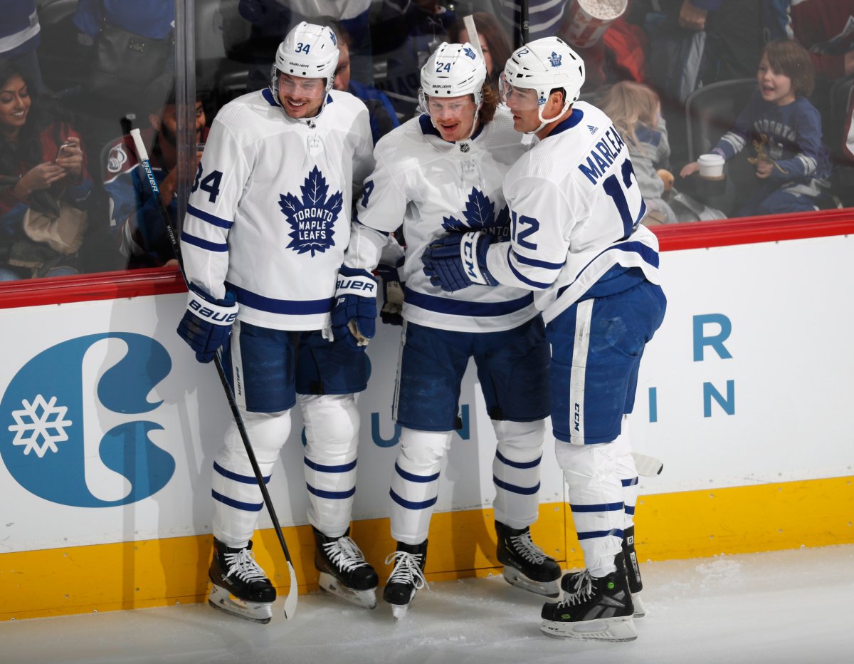 Toronto Maple Leafs right wing Kasperi Kapanen, center, is congratulated after scoring a goal by centers Auston Matthews, left, and Patrick Marleau in the first period of an NHL hockey game against the Colorado Avalanche, Tuesday, Feb. 12, 2019, in Denver.