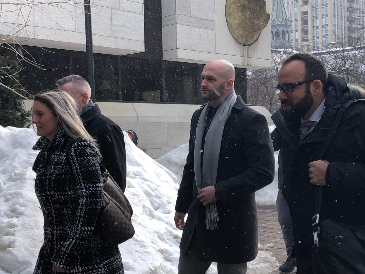 Const. Daniel Montsion (centre) arrives with his defence lawyer Solomon Friedman (right) at the Ottawa courthouse on Elgin Street on Feb. 25, 2019.