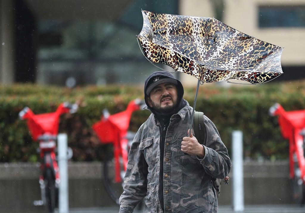 High winds caused havoc for a man using an umbrella as rain pelted Sacramento, Calif., Tuesday, Feb. 26, 2019.