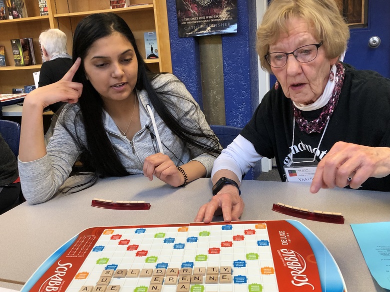 Raminder Gill and Vicki Strang play a game of Scrabble together.