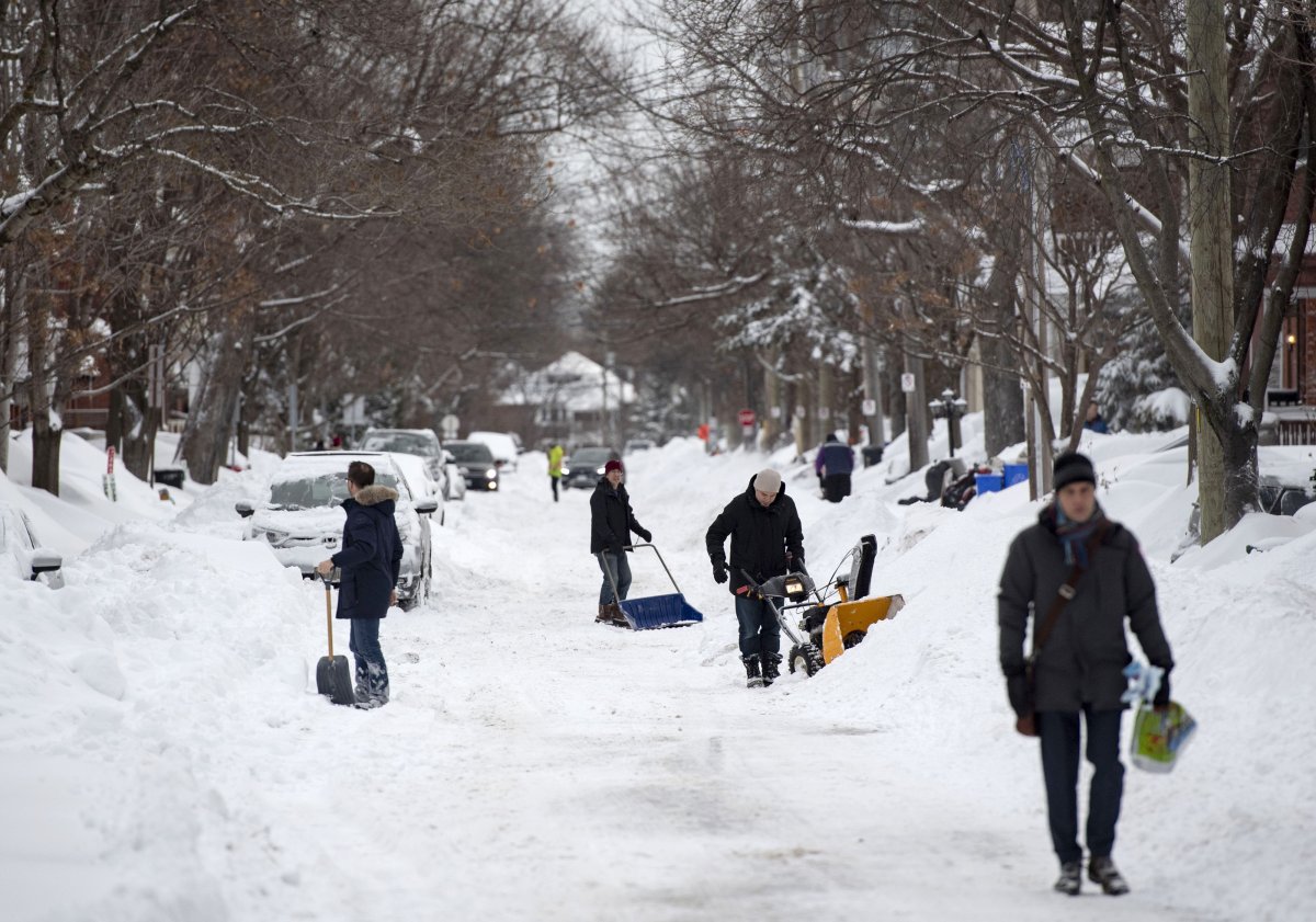 People dig out their cars and driveways in Ottawa's Glebe neighbourhood during a winter storm on Wednesday, Feb. 13, 2019. The storm, which began on Tuesday afternoon, is expected to bring 30-40 centimetres of snow by Wednesday. All Ottawa-area schools are closed and classes were cancelled for a 24 hour period at the University of Ottawa and Carleton University.