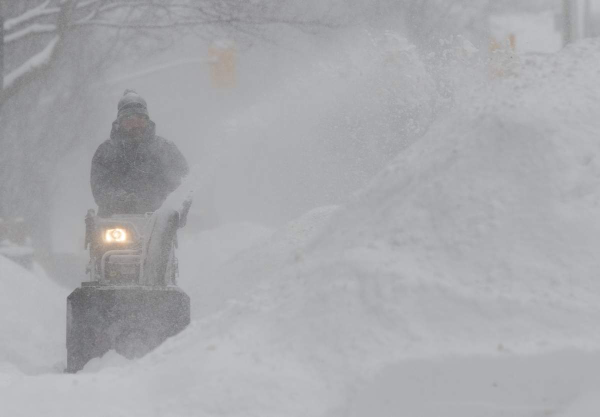 J.F. Messier clears snow from his neighbours driveway in Ottawa on Wednesday January 23, 2019.