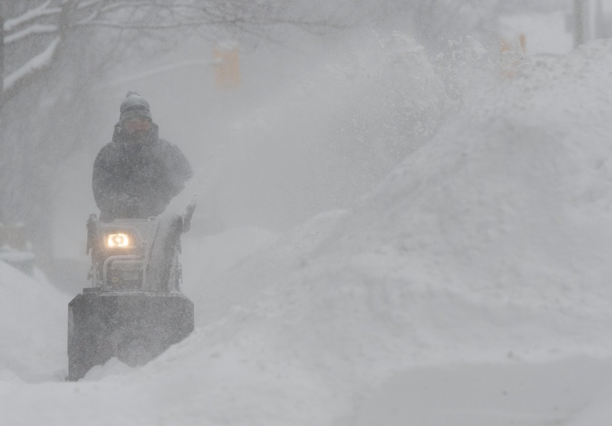 J.F. Messier clears snow from his neighbours driveway in Ottawa on Wednesday January 23, 2019.