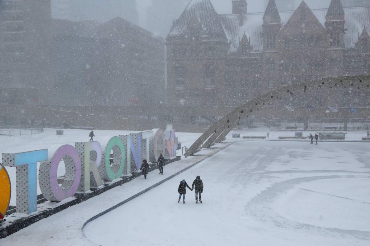 A couple skates during a snow blizzard at the ice rink outside City Hall in Toronto, Ontario, Canada January 28, 2019.