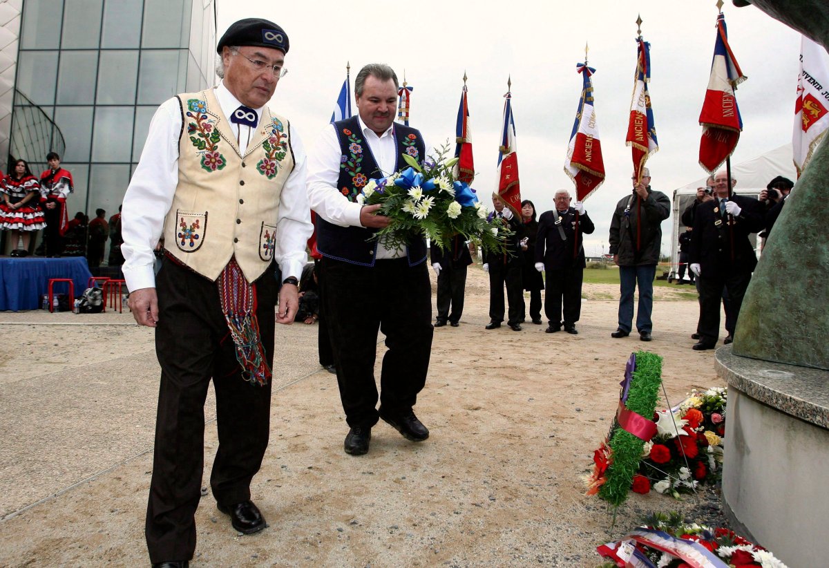 Canada's Clement Chartier, President of the Metis National Council, left, and David Chartran, Minister of Veterans Affairs for the Metis National Council, second from left, lay a wreath at a monument during ceremonies to honors Metis veterans of WWII, at Juno Beach Center, near Caen, Normandy, on Nov. 11, 2009. 