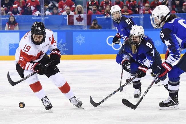 In this Feb. 22, 2018, file photo, Canada forward Brianne Jenner chases the puck as U.S. defencewomen Emily Pfalzer and Megan Keller look on during the gold medal game at the 2018 Olympic Winter Games in Gangneung, South Korea.