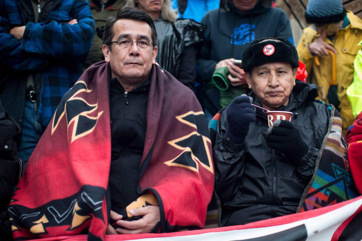 Union of B.C. Indian Chiefs Vice President Chief Bob Chamberlin, left, and Grand Chief Stewart Phillip, President of the Union of B.C. Indian Chiefs, join protesters opposed to the Kinder Morgan Trans Mountain pipeline extension and defy a court order blocking an entrance to the company's property, in Burnaby, B.C., on Saturday April 7, 2018.