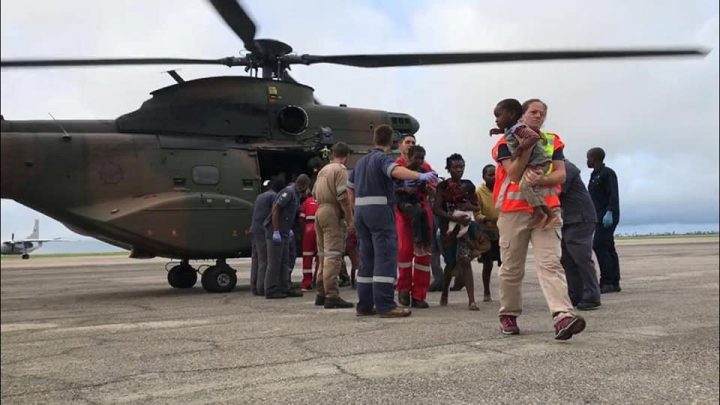 Rescue workers help affected people disembark from a helicopter after cyclone damage in Beira, Mozambique, March 19, 2019.