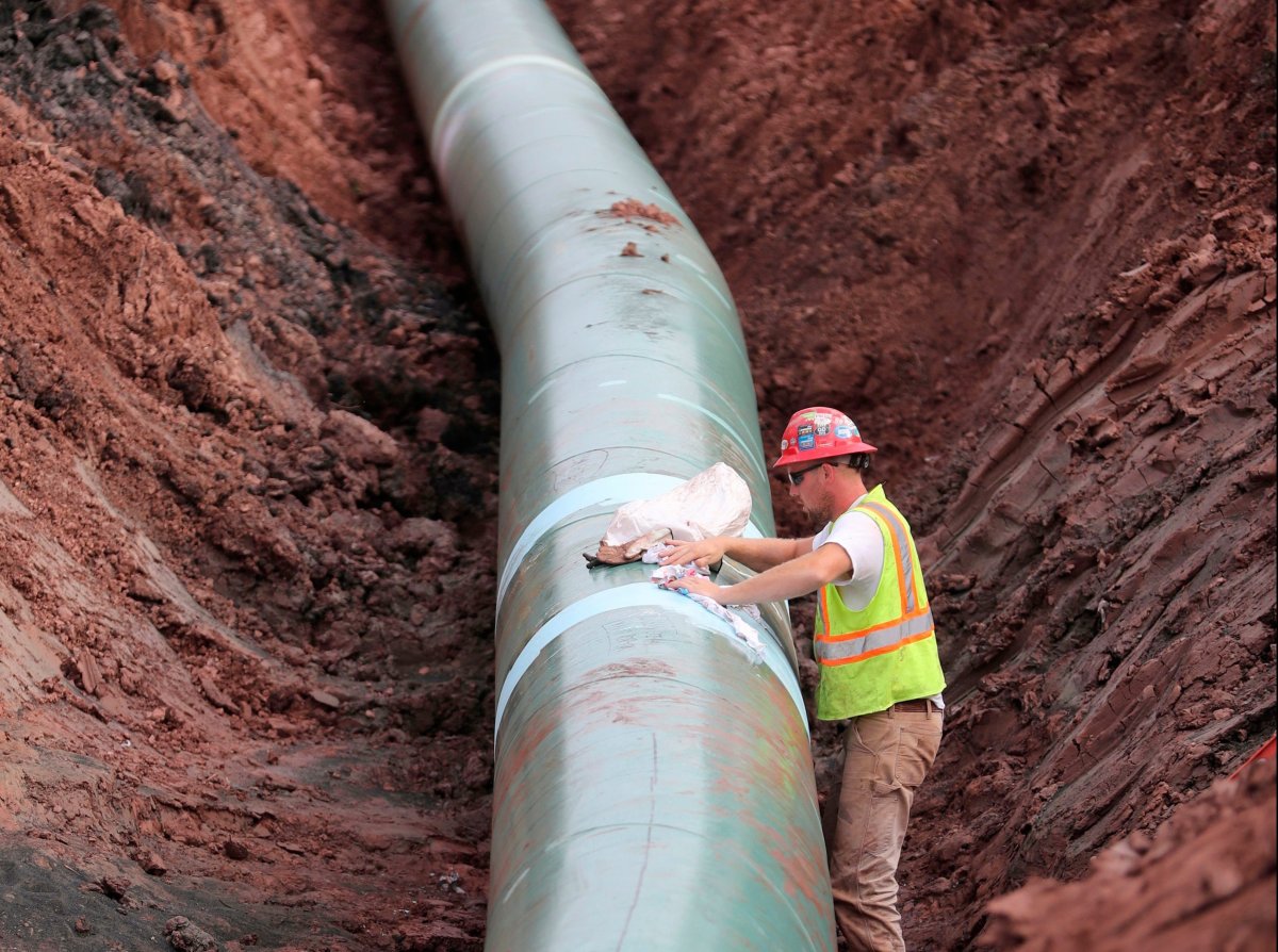 In this Aug. 21, 2017, file photo, a pipe fitter lays the finishing touches to the replacement of Enbridge Energy's Line 3 crude oil pipeline stretch in Superior, Minn. 