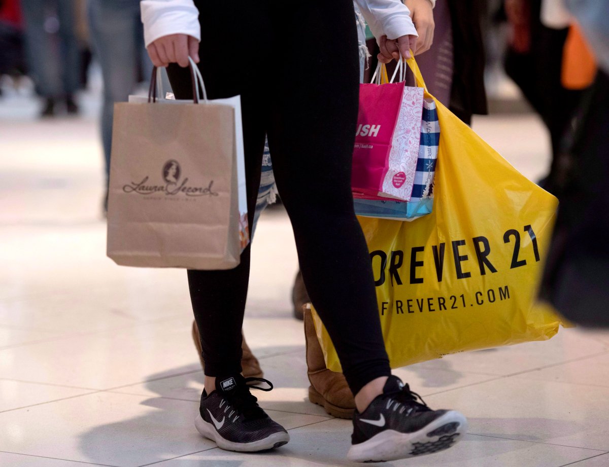 A shopper carries their purchases in shopping bags as they walk in a mall on Boxing Day, Wednesday, Dec. 26, 2018. THE CANADIAN PRESS/Justin Tang.