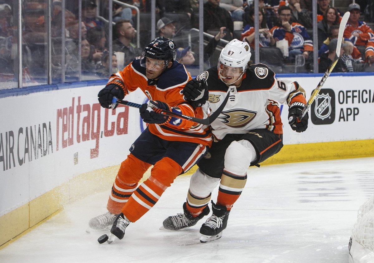 Anaheim Ducks' Rickard Rakell (67) and Edmonton Oilers' Andrej Sekera (2) battle for the puck during third period NHL action in Edmonton, Alta., on Saturday February 23, 2019. THE CANADIAN PRESS/Jason Franson.
