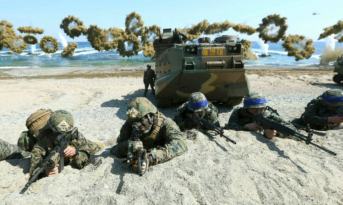 FILE - In this March 12, 2016, file photo, Marines of the U.S., left, and South Korea, wearing blue headbands on their helmets, take positions after landing on a beach during the joint military combined amphibious exercise, called Ssangyong, part of the Key Resolve and Foal Eagle military exercises, in Pohang, South Korea.