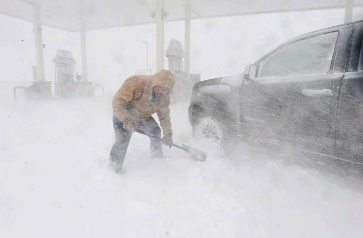 Greg Giannini, out getting gas for his generator, got stuck at the pumps despite having 4-wheel drive and had to dig out to get home as the blizzard swirled around him in Colorado Springs, Colorado, on Wednesday, March 13, 2019.