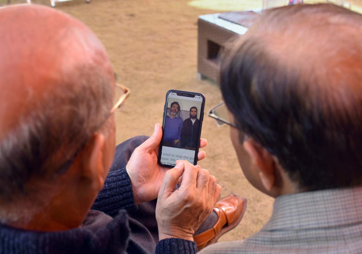 Relatives look at the pictures of Pakistani citizen Rashid Naeem and his son, Talha Naeem, who were reportedly killed in the Christchurch mosque shooting, in a cellphone at their home in Abbottabad, Pakistan, Saturday, March 16, 2019.