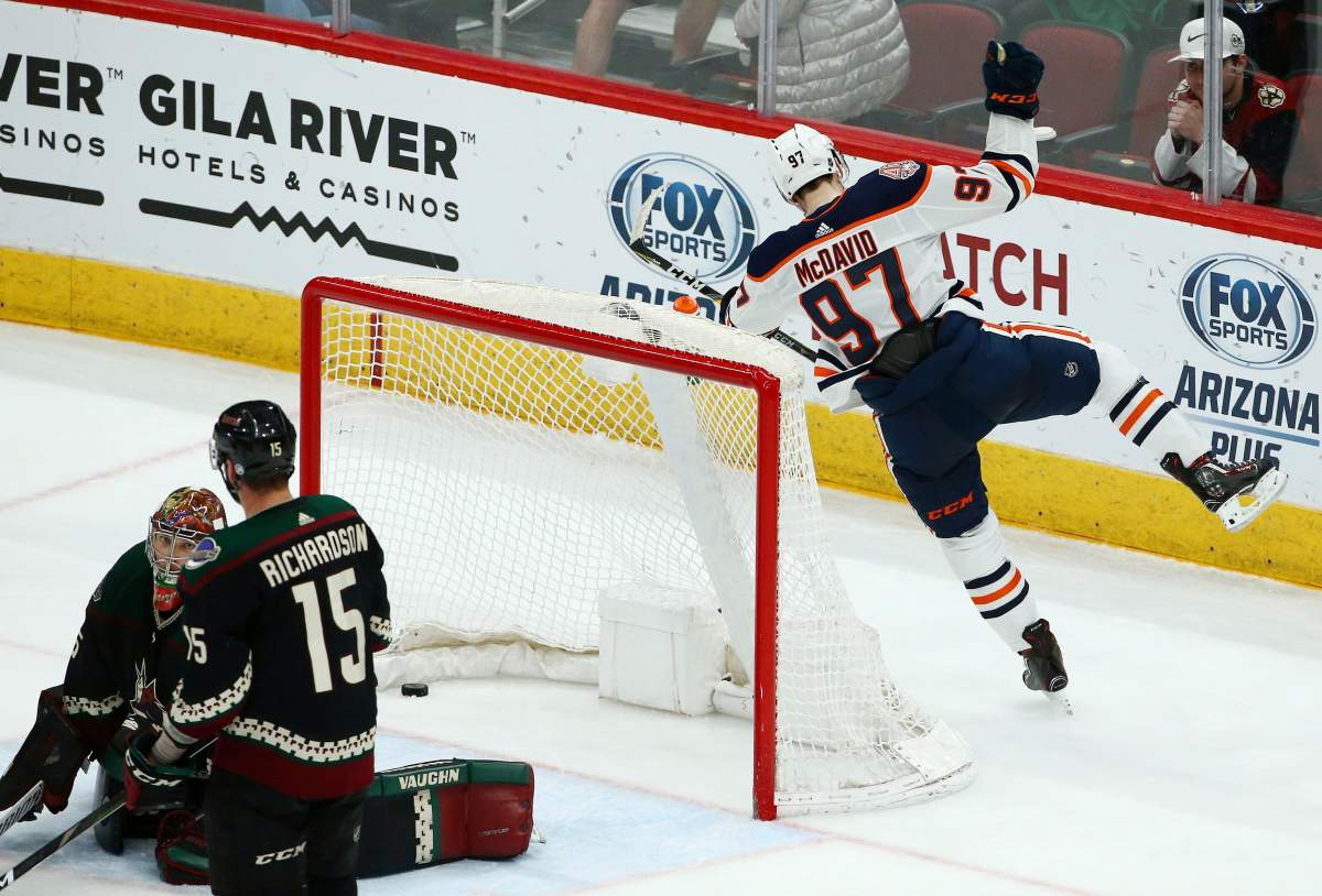 Edmonton Oilers center Connor McDavid (97) celebrates his game-winning goal against Arizona Coyotes goaltender Darcy Kuemper, left, as Coyotes center Brad Richardson (15) kneels next to Kuemper during overtime of an NHL hockey game Saturday, March 16, 2019, in Glendale, Ariz. The Oilers won 3-2. (AP Photo/Ross D. Franklin).