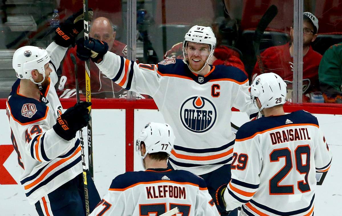 Edmonton Oilers center Connor McDavid (97) smiles as he celebrates his game-winning goal against the Arizona Coyotes with Zack Kassian (44), Oscar Klefbom (77) and Leon Draisaitl (29) during overtime of an NHL hockey game Saturday, March 16, 2019, in Glendale, Ariz. The Oilers won 3-2.