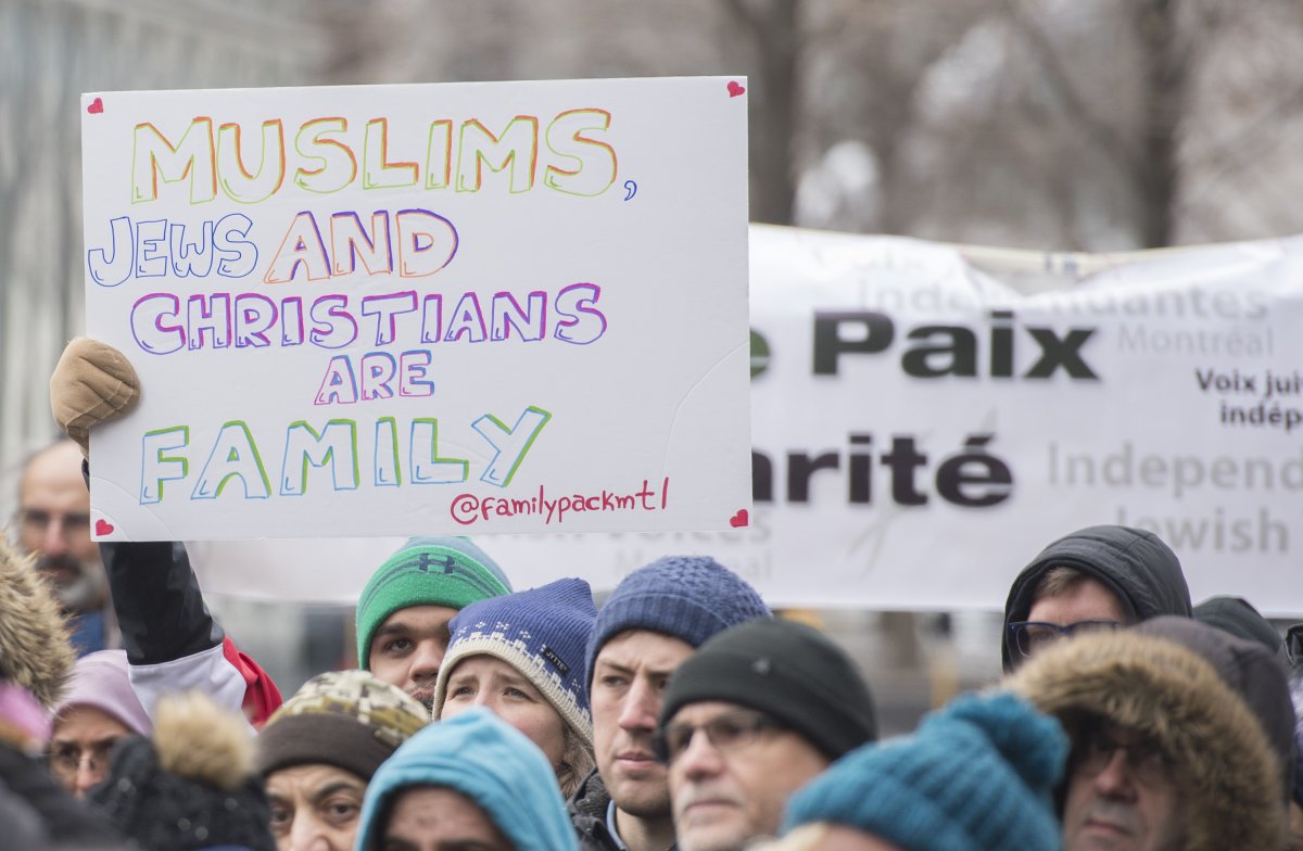 People hold up signs as they attend a vigil in Montreal, Sunday, March 17, 2019, following a shooting at a mosque in Christchurch, New Zealand which left 50 people dead and many more injured.