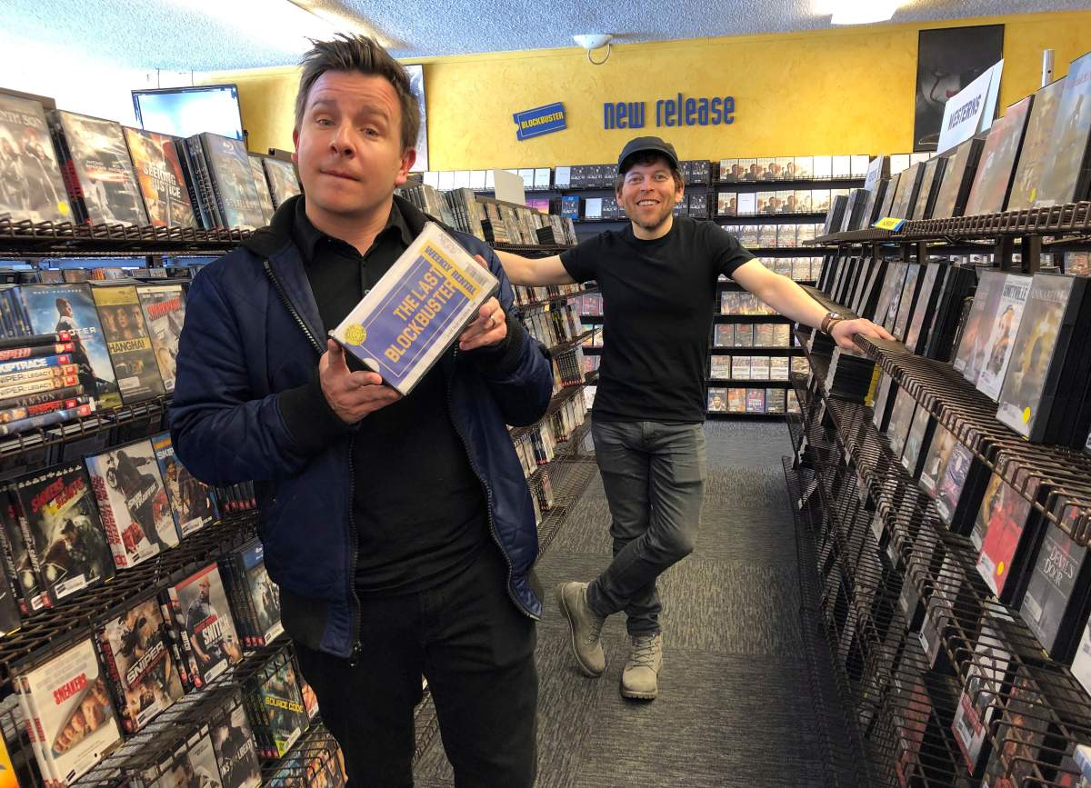 Local documentary filmmakers Taylor Morden, left, and Zeke Kamm, pose at the last Blockbuster on the planet in Bend, Ore., on Monday, March 11, 2019, with a promotional VHS tape of their upcoming documentary about the store titled ‘The Last Blockbuster.’