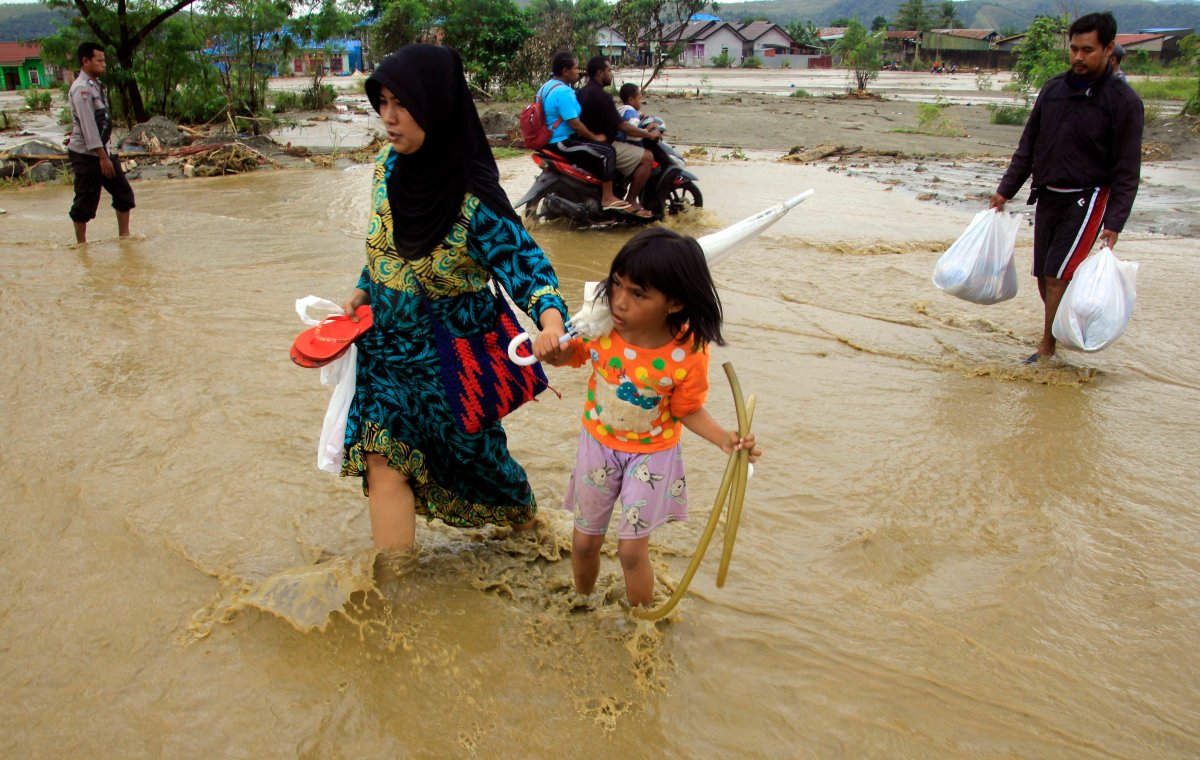 Residents carry their belongings as they wade through flood water in Sentani, near Jayapura, Papua province, Indonesia, 18 March 2019. At least 79 people were killed and 43 missing as a flash floods hit Sentani on 16 March, according to Sutopo Purwo Nugroho, a spokesman for the National Disaster Management Agency.