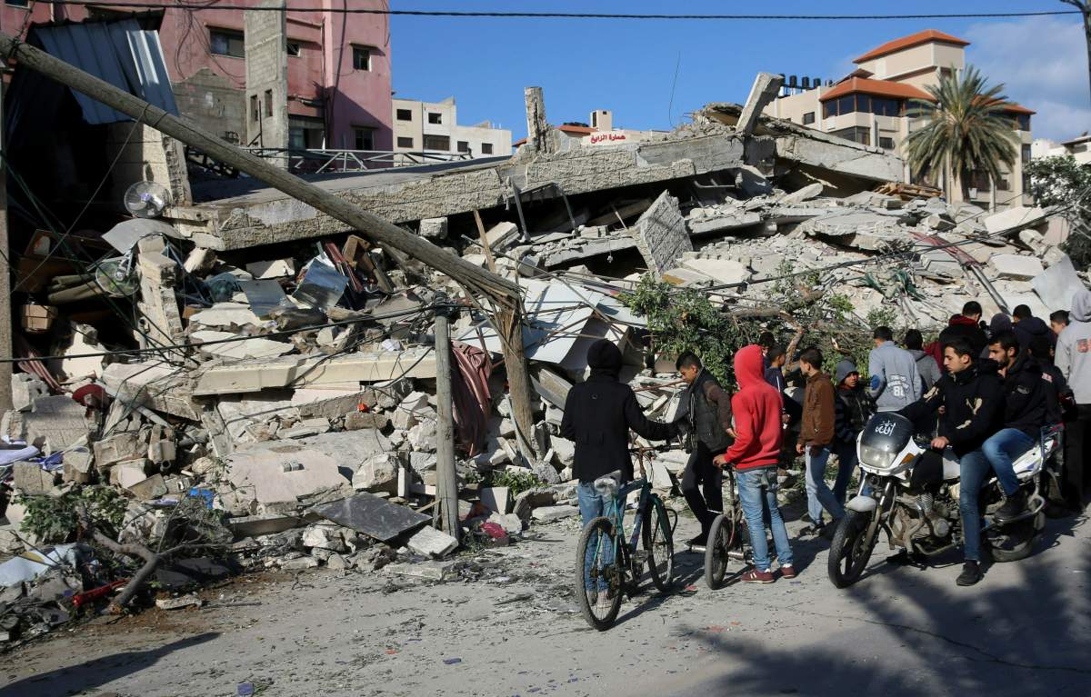 Residents inspect the damage of the destroyed multi-story building of Hamas-affiliated insurance company, in Gaza City, Tuesday, March 26, 2019.