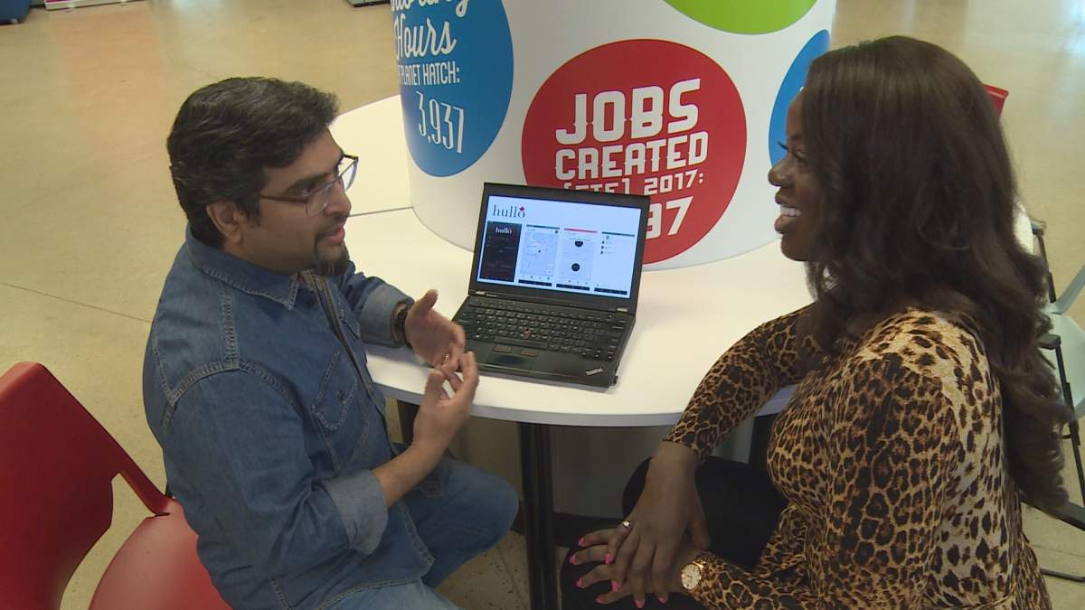 Ali Allauddin Ajani demos the app for Megan Yamoah