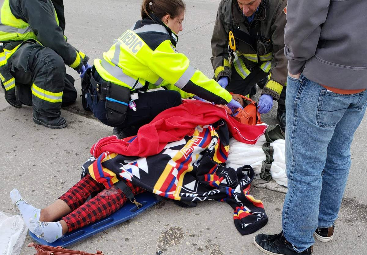 A woman who was hit by a vehicle near the Slaw Rebchuk Bridge is attended to by paramedics.