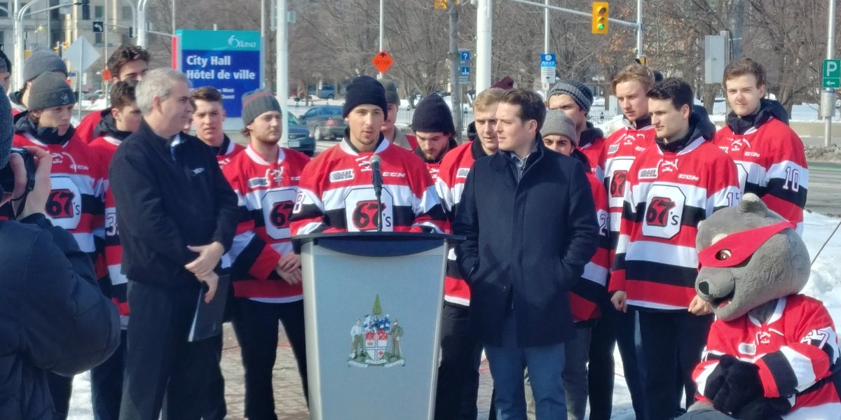 67's centre Sasha Chmelevski (centre), along with Couns. Riley Brockington (left) and Mathieu Fleury, speaks to a crowd of fans during a flag-raising ceremony at city hall on Tuesday celebrating the team's successful season and playoff berth. 