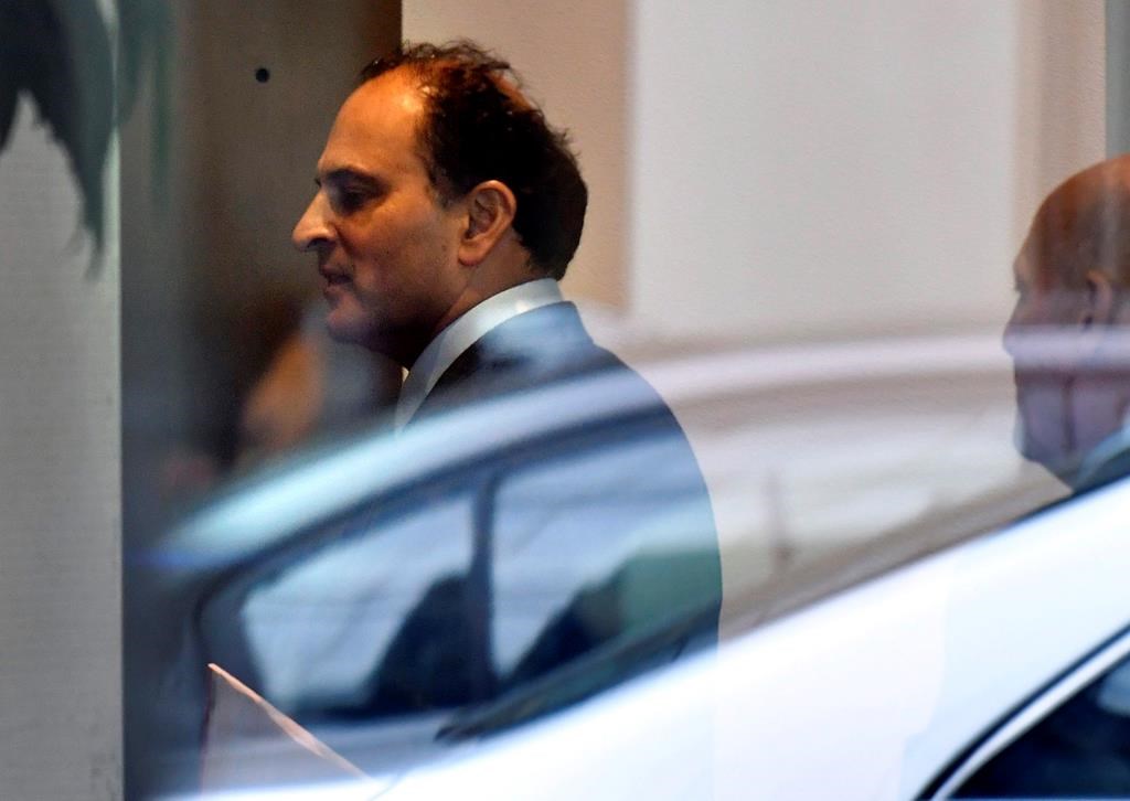 David Sidoo, of Vancouver enters an adjacent building with his lawyer following a federal court hearing Friday, March 15, 2019, in Boston. Sidoo faced charges of conspiracy to commit mail and wire fraud as part of a wide-ranging college admissions bribery scandal.
