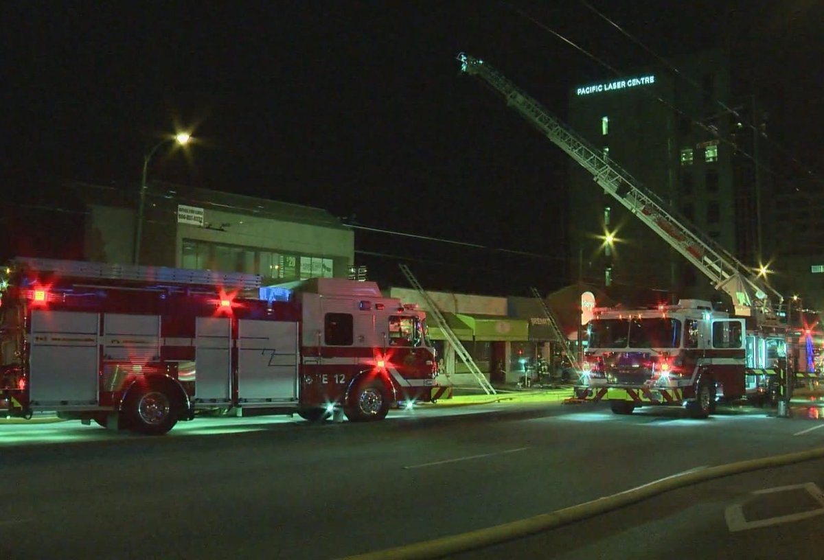 Fire crews convene outside the Eat Your Cake bakery on West Broadway early Sunday morning, after a fire broke out in the basement just before midnight.