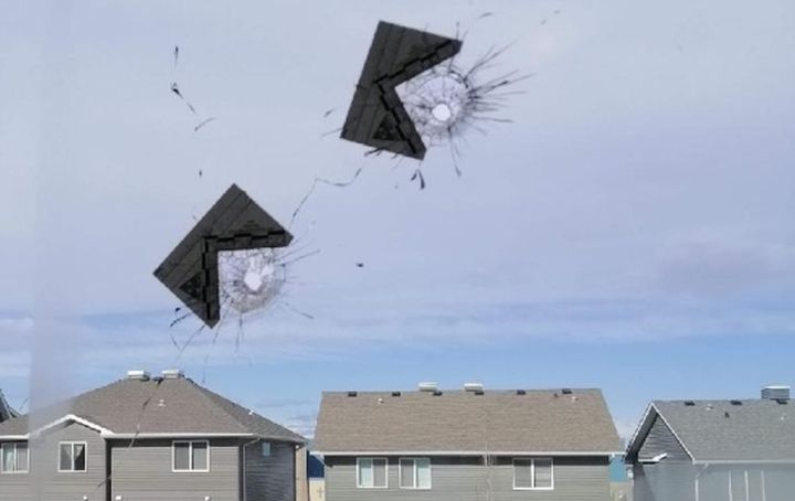 Bulletholes are seen in the window of a southeast Calgary home on March 26, 2019.