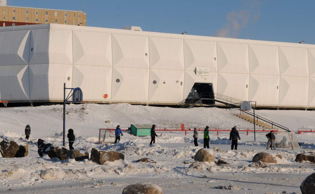 Youths play ice hockey on an outdoor rink in front of the Nakasuk Elementary School in Iqaluit, the capital of Nunavut, Canada on February 16, 2014.