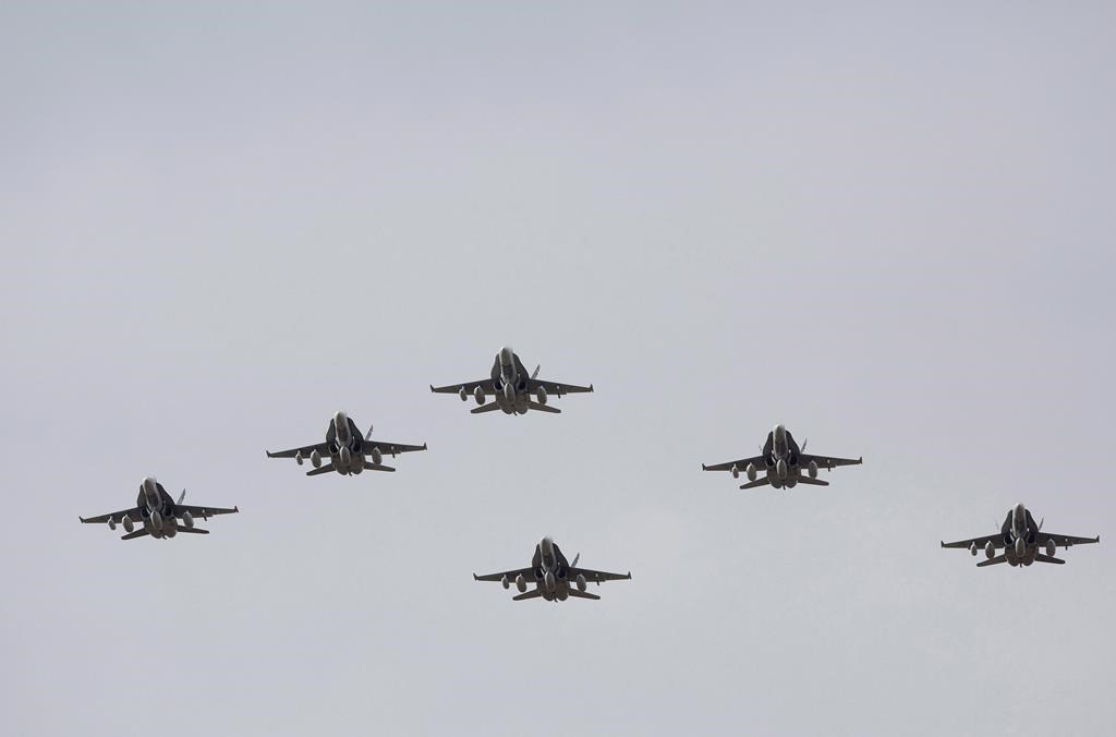 CF-18 Hornets fly in formation on their the departure for Operation IMPACT, in Cold Lake, Alberta on Tuesday October 21, 2014. THE CANADIAN PRESS/Jason Franson.